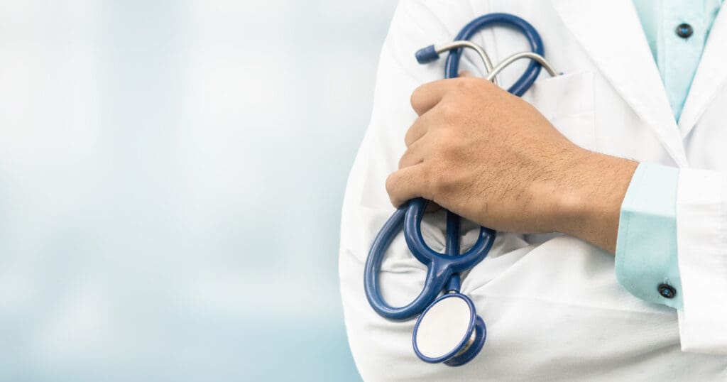 A doctor holding a stethoscope, with arms crossed