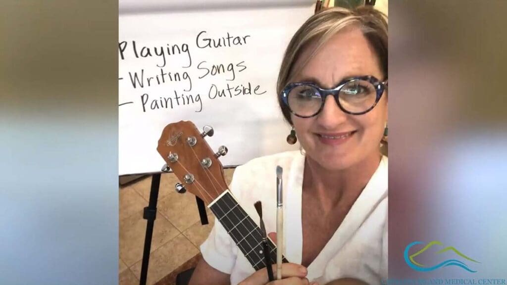 Kymberlee Stanley, LCSW, playing a ukulele to demonstrate things that make her smile