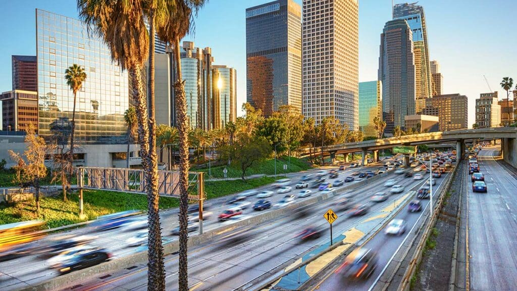 Sunset in dowtown LA, gleaming buildings and heavy traffic