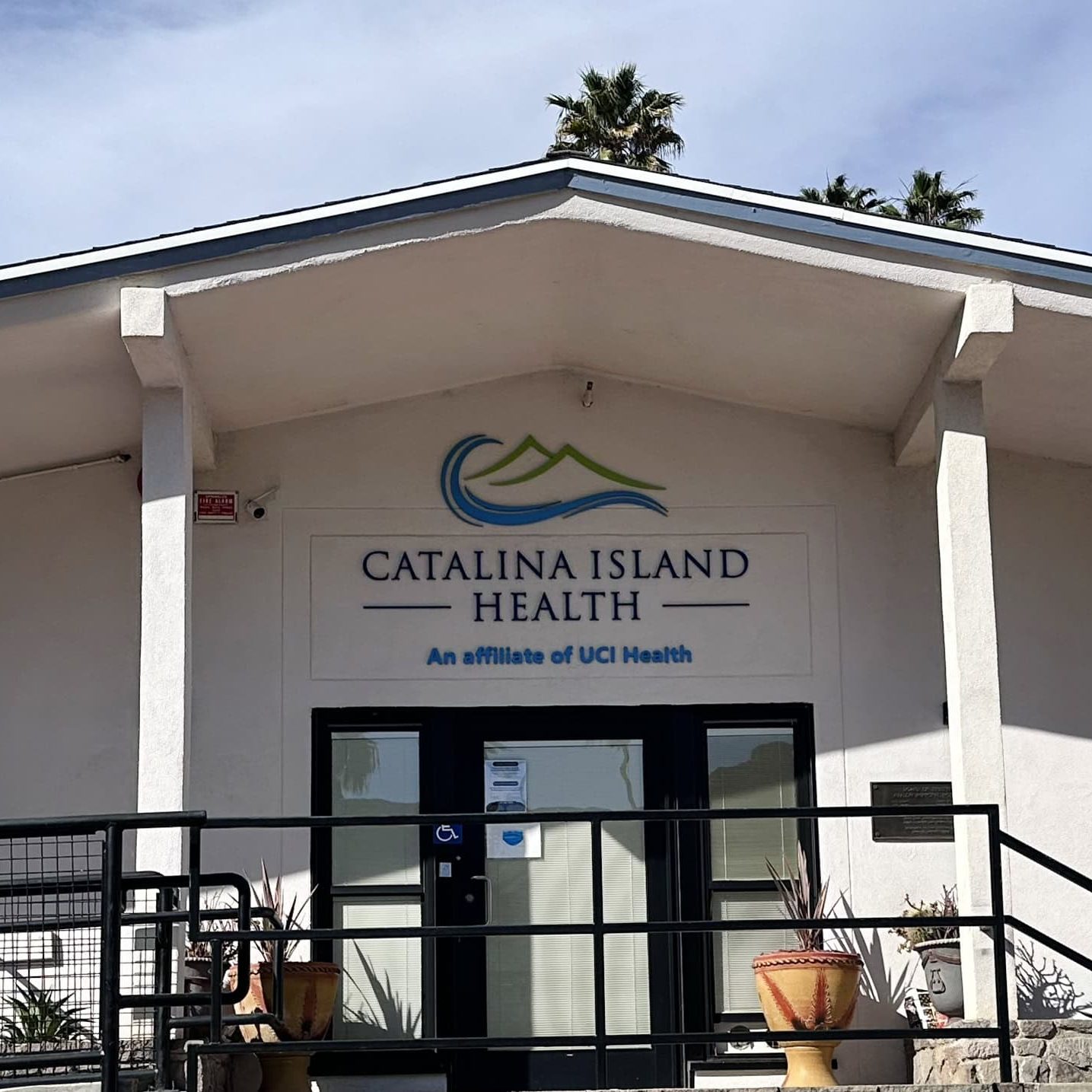 Catalina Island Health clinic building on a sunny day with palm trees.