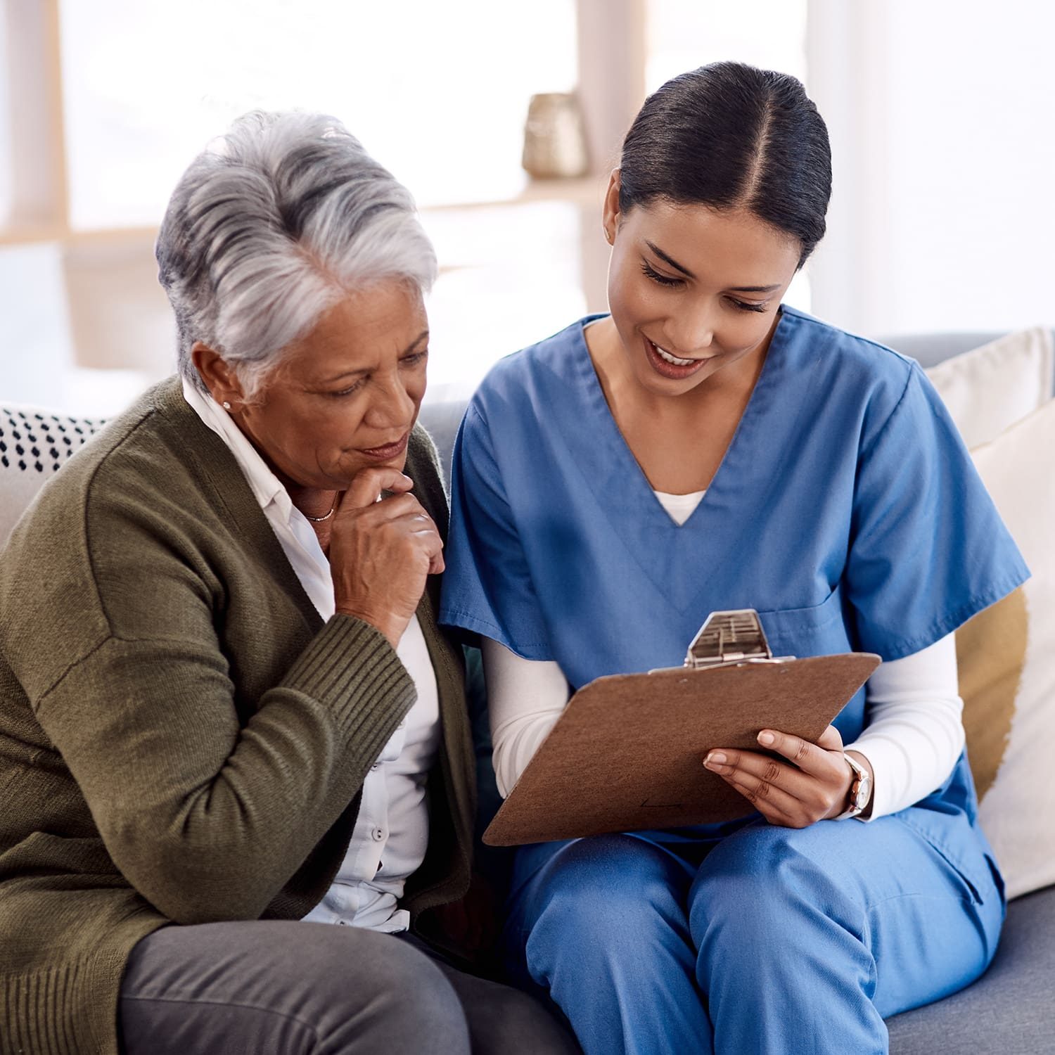 Shot of a young nurse going through paperwork with a senior woman